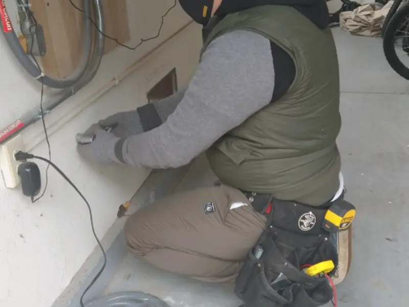 Electrician performing outlet wiring in a Bailey's Crossroads garage